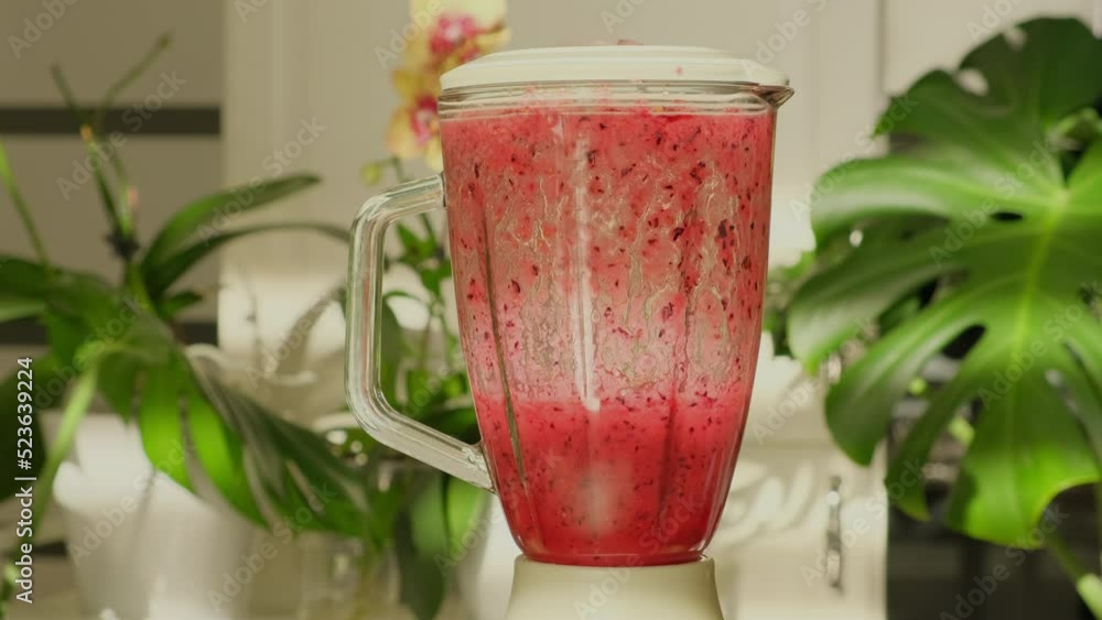 Smoothie with fresh strawberry and milk close-up. Making fresh fruits smoothie with red strawberries blended in blender. Concept of healthy vegetarian organic food, detox, dieting Smoothie with fresh strawberry and milk close-up. Making fresh fruits smoothie with red strawberries blended in blender. Concept of healthy vegetarian organic food, detox, dieting