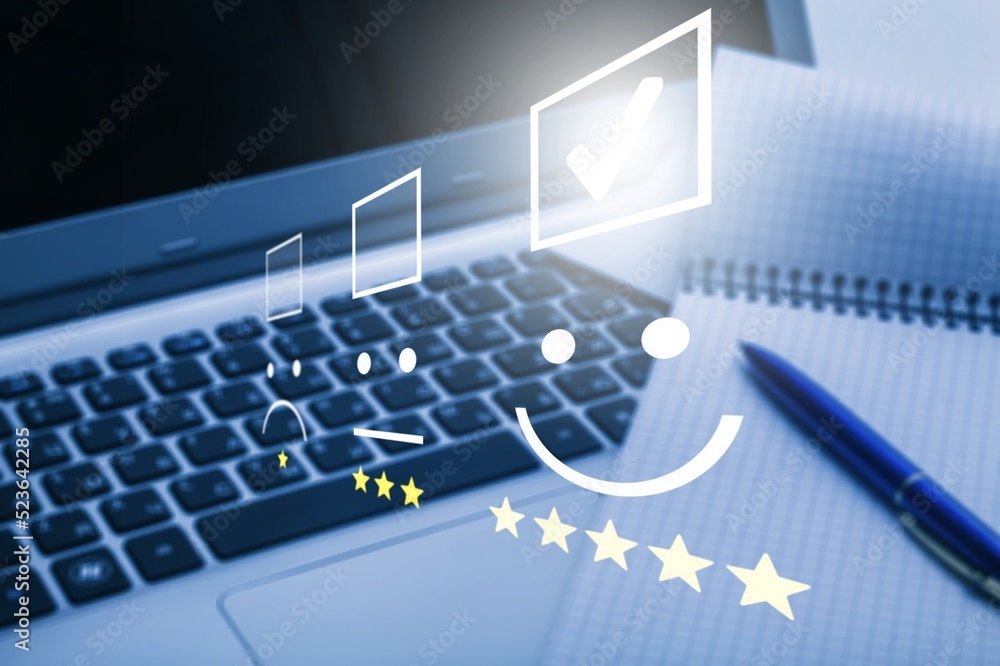 Pressing face emoticon on touch screen at laptop. Customer Service