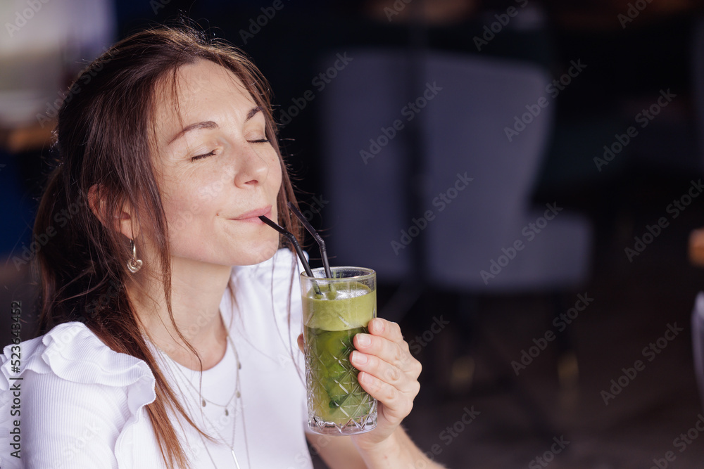 girl drink healthy fresh cocktail in modern cafe