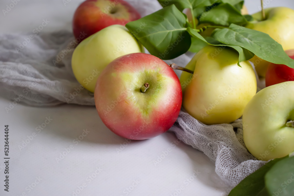 Fresh apples with leaves on a light background Fresh apples with leaves on a light background