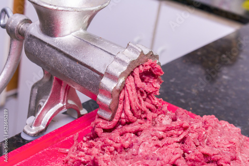 Minced beef with antique Metal manual meat grinder.