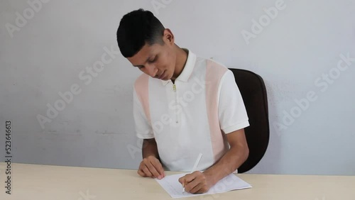 latin male student writing on paper. mexican man in office