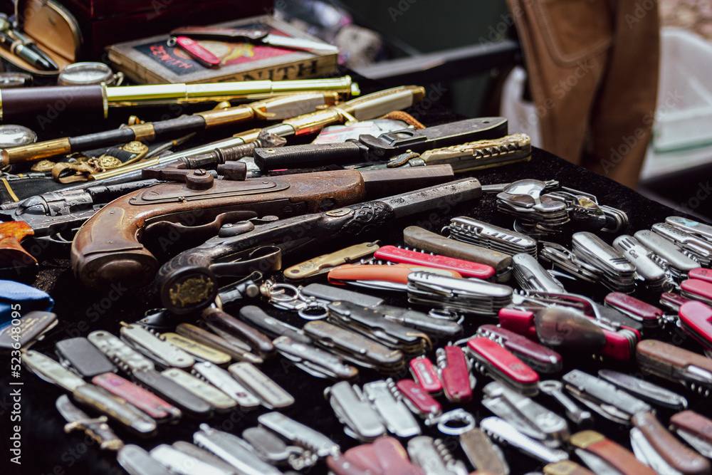 Collection of antique weapons at the flea market. Muskets and edged ...