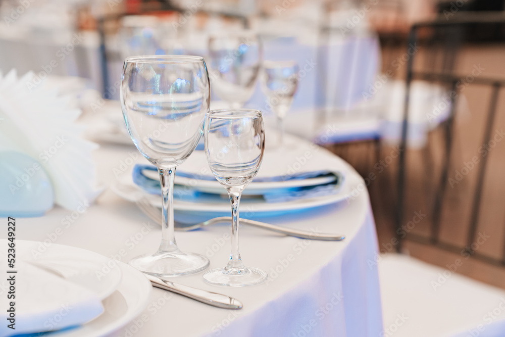 empty wine glasses on a round table with a white tablecloth. empty wine glasses on a round table with a white tablecloth.