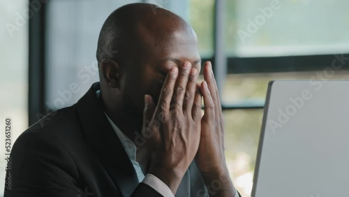 Tired stressful african male adult sad businessman feel tiredness discomfort eyestrain fatigue pain from hard overwhelmed computer work massaging dry irritable eyes exhaustion unwell health concept