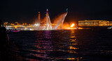 A lot of flyboarders and brightly dressed up jet skiers perform their show at a holiday in the center of St. Petersburg at night, water activities