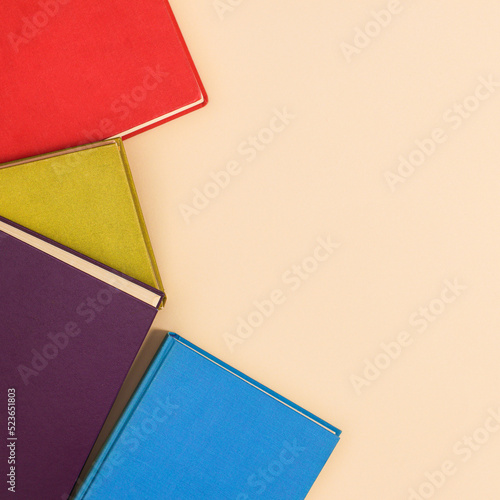 Creative copy space beige background with colorful vibrant vintage books. Flat lay