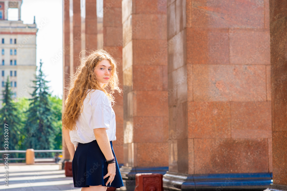 beautiful girl student entering the university to attend classes on a sunny day. beautiful girl student entering the university to attend classes on a sunny day.