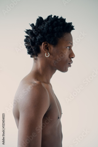 silhouette of a muscular african man posing in a photo studio on a white background without a t-shirt close-up portrait