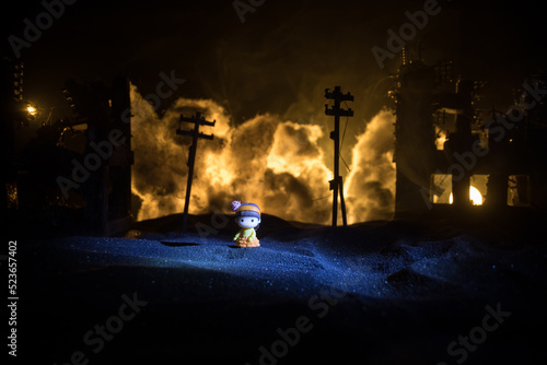 Silhouette soldier carrying little boy on his shoulder from fire. Rescue savior concept. Man moving out with little boy from burned out city destroyed in war. Selective focus