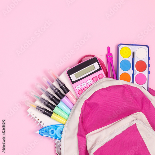 Back to school backpak with school stationery on pastel pinkbackground. Flat lay photo