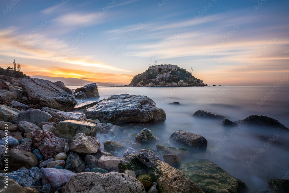 pireas greek sunrise long exposure rocks sand and island