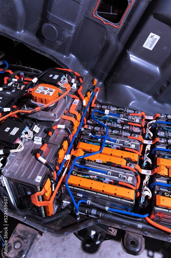 Electric car battery with power connections closeup. Blue toned. EV car battery at maintenance.