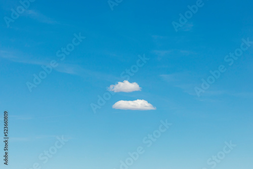 scenic puffy small couple of clouds cloud under blue sky,