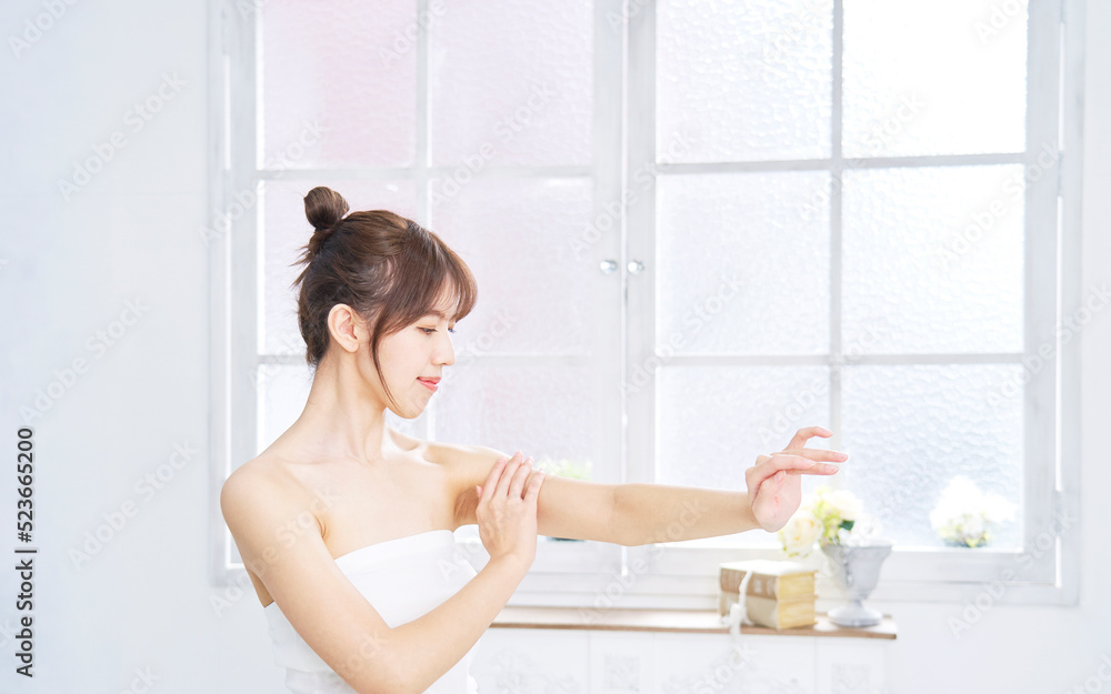 自宅で腕のケアをする女性 自宅で腕のケアをする女性