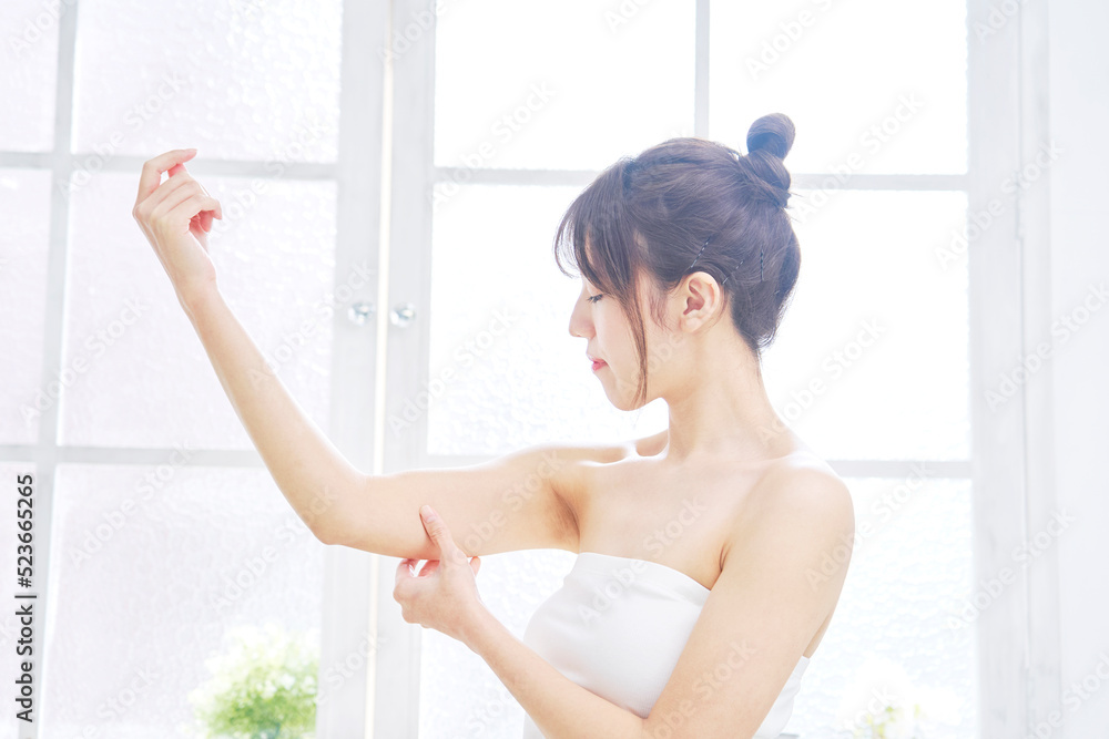 二の腕の肉を摘む女性女性