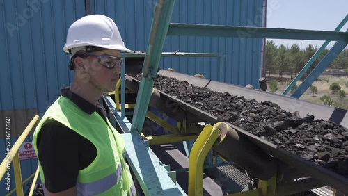 Coal power plant.
The engineer inspects the coal on the conveyor belt.
