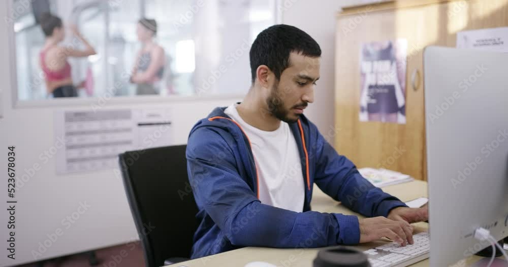 Gym manager or owner working in an office typing a business growth proposal or strategy on a computer. Fit and young fitness facility employees writing and planning a budget for the startup Gym manager or owner working in an office typing a business growth proposal or strategy on a computer. Fit and young fitness facility employees writing and planning a budget for the startup