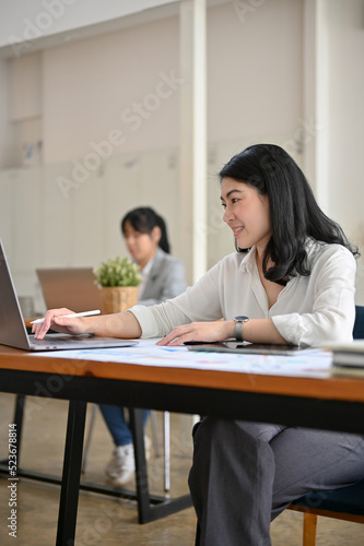 Professional Asian businesswoman working, using laptop computer at her office