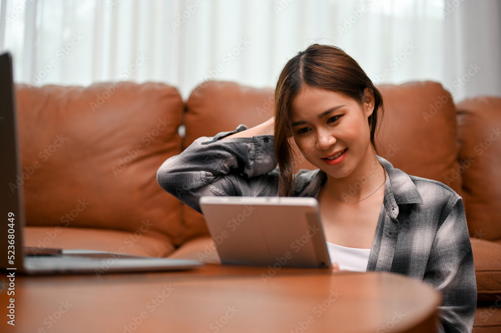 Pretty Asian young woman uses digital tablet to chat with her online friends Pretty Asian young woman uses digital tablet to chat with her online friends