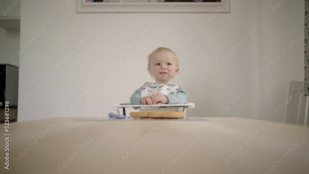 Lockdown Shot Of Toddler With Baby Bib Sitting On Highchair Against Wall At Home - Jablonec nad Nisou, Czechia Lockdown Shot Of Toddler With Baby Bib Sitting On Highchair Against Wall At Home - Jablonec nad Nisou, Czechia