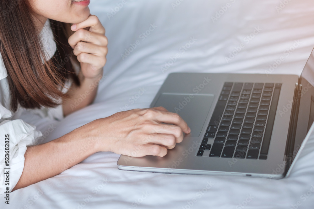 Happy woman using laptop for work, female meeting online by computer notebook on bed. technology, network, work from home, lifestyle and digital communication concept Happy woman using laptop for work, female meeting online by computer notebook on bed. technology, network, work from home, lifestyle and digital communication concept
