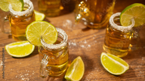 tequila shots served in jars with salt and lime on wooden table