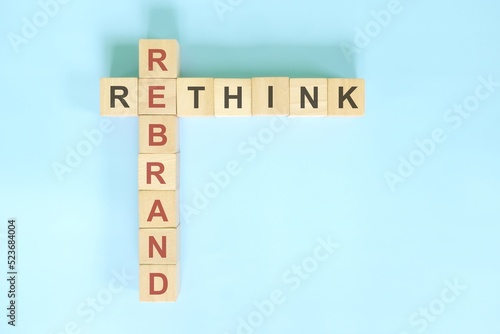Obraz na płótnie Rethink and rebrand business concept. Wooden blocks crossword puzzle flat lay in blue background. w salonie