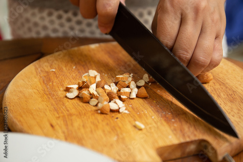 Close up of housewife cutting almond on cutting board for breakfast