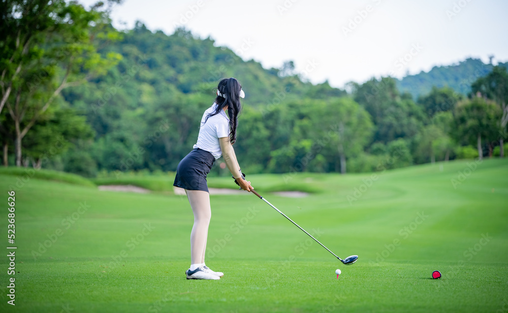 Obraz premium Professional woman golfer teeing golf in golf tournament competition at golf course for winner. 