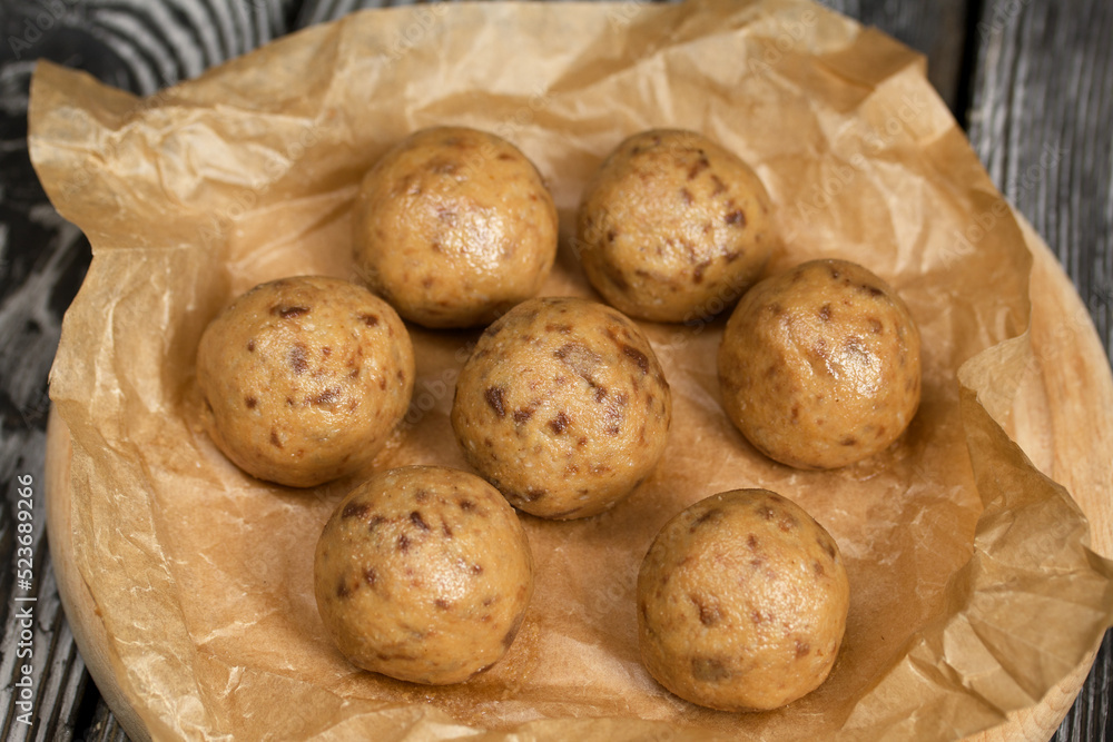 Useful homemade sweets. Coconut flour with dark chocolate. In the form of balls. On pine boards. Useful homemade sweets. Coconut flour with dark chocolate. In the form of balls. On pine boards.