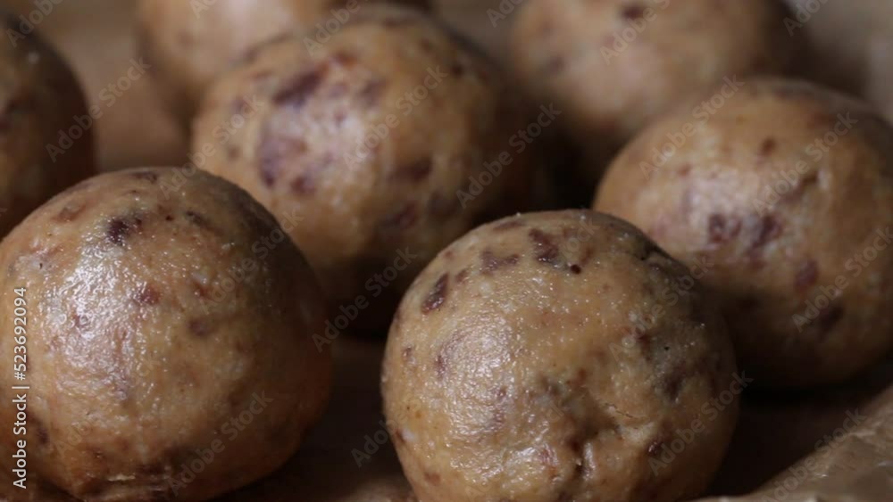 Useful homemade sweets. Coconut flour with dark chocolate. In the form of balls. On pine boards. Close-up. Slider camera. Useful homemade sweets. Coconut flour with dark chocolate. In the form of balls. On pine boards. Close-up. Slider camera.