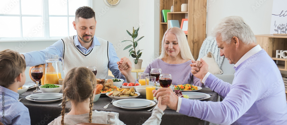 Family praying before celebrating Thanksgiving Day at home Family praying before celebrating Thanksgiving Day at home