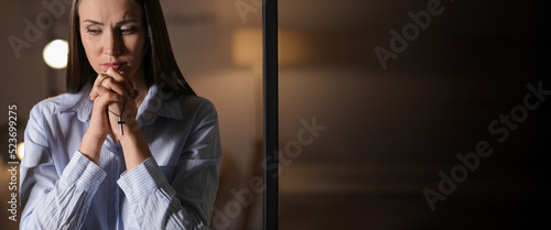 Praying young woman at home...