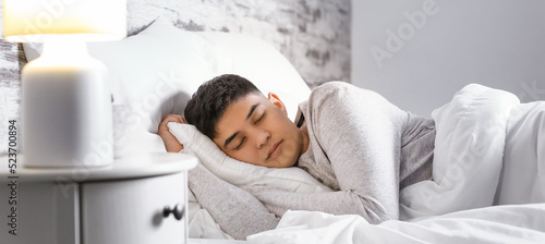 Asian man sleeping in bed