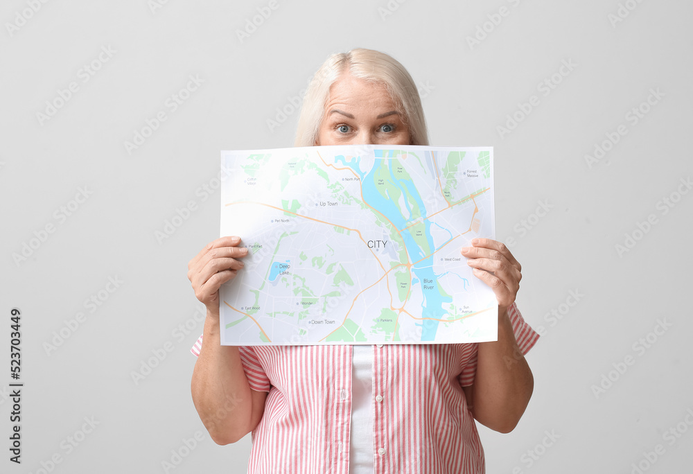 Mature woman with city map on light background Mature woman with city map on light background