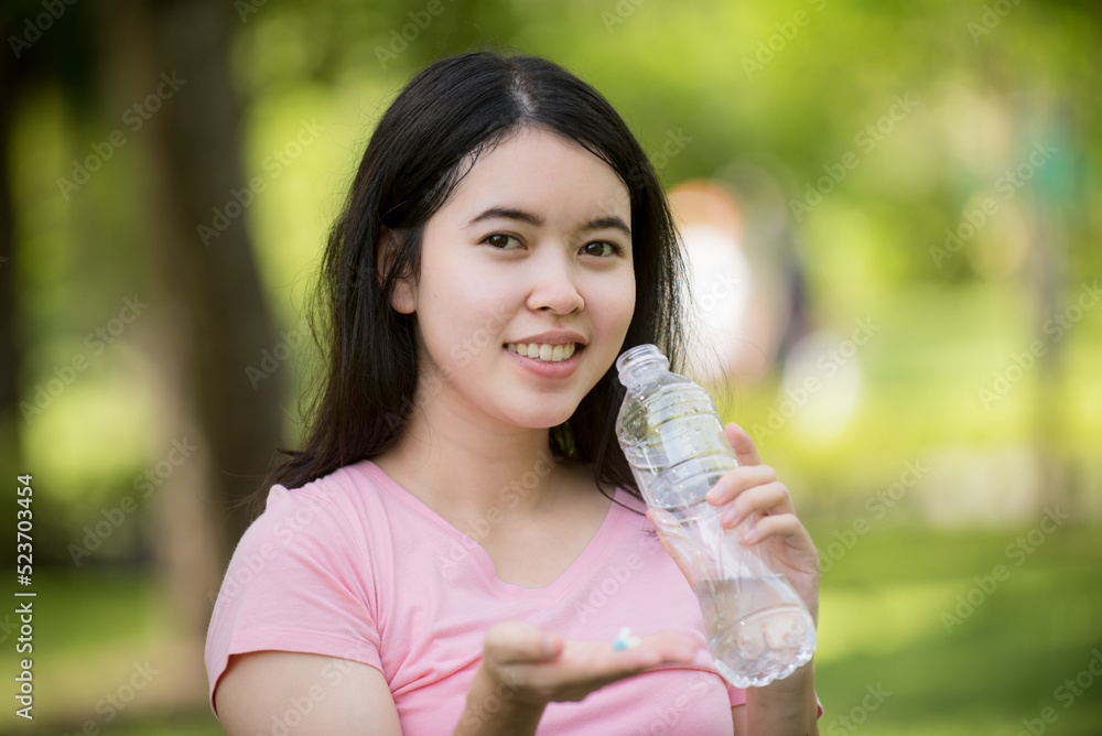 Happy pregnant Asian woman sitting on lawn and drinking water. Pregnancy, motherhood, people and expectations. Happy pregnant Asian woman sitting on lawn and drinking water. Pregnancy, motherhood, people and expectations.