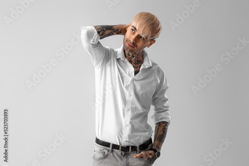 Young tattooed man in white...