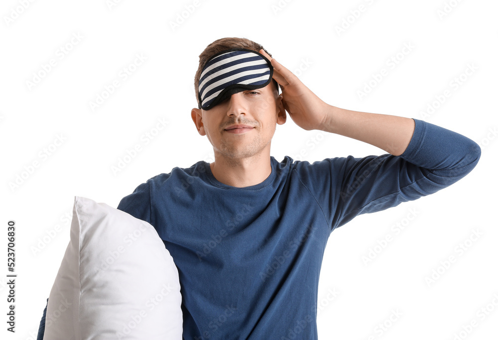 Young man with sleeping mask and pillow on white background Young man with sleeping mask and pillow on white background