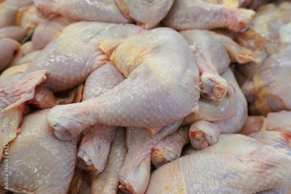 Chicken leg pieces stacked together in a shop for sale. Chicken leg pieces stacked together in a shop for sale.