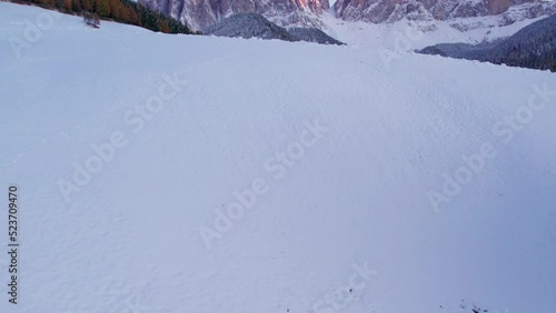 Winter snow covered field in peaceful Alpine valley during sunset, Dolomites photo