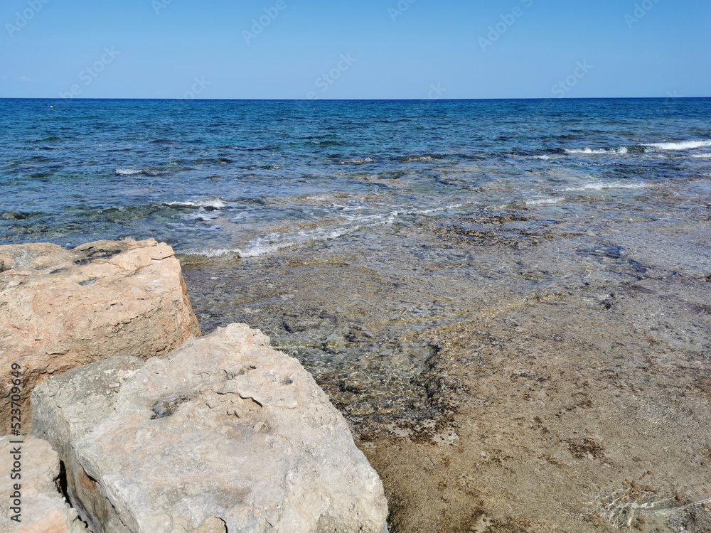 Protaras. Famagusta area. Cyprus. Rocky shore of long-hardened lava, cliff, clear water of the Mediterranean Sea. Protaras. Famagusta area. Cyprus. Rocky shore of long-hardened lava, cliff, clear water of the Mediterranean Sea.