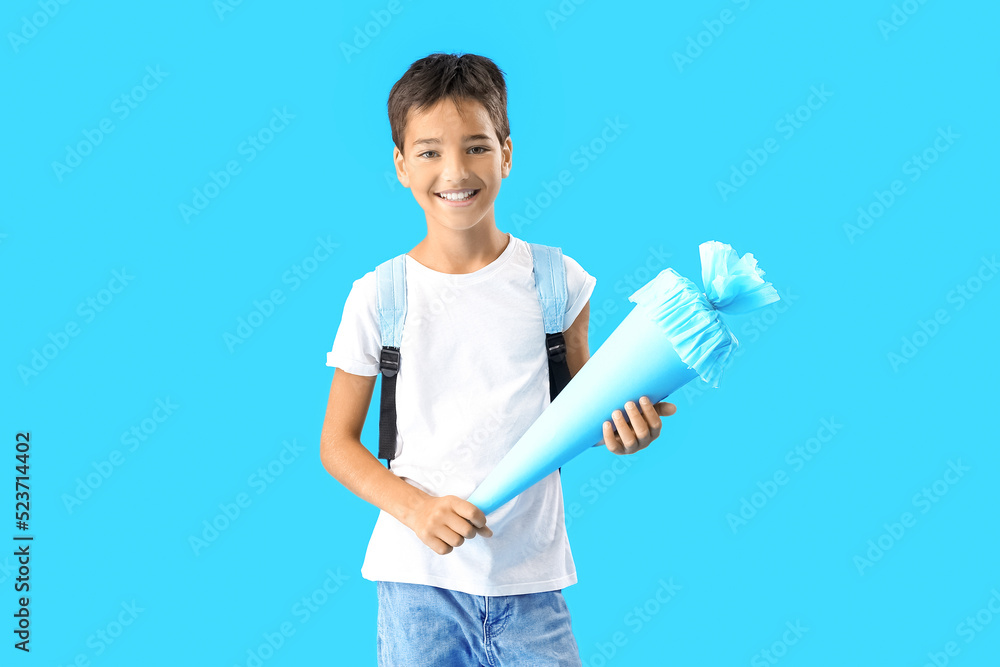 Little boy with school cone on blue background Little boy with school cone on blue background