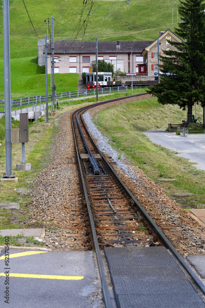 Fototapeta premium Railway track of light railway of Matterhorn Gotthard Railway to Swiss mountain pass Oberalppass on a sunny summer day. Photo taken July 3rd, 2022, Andermatt, Switzerland.