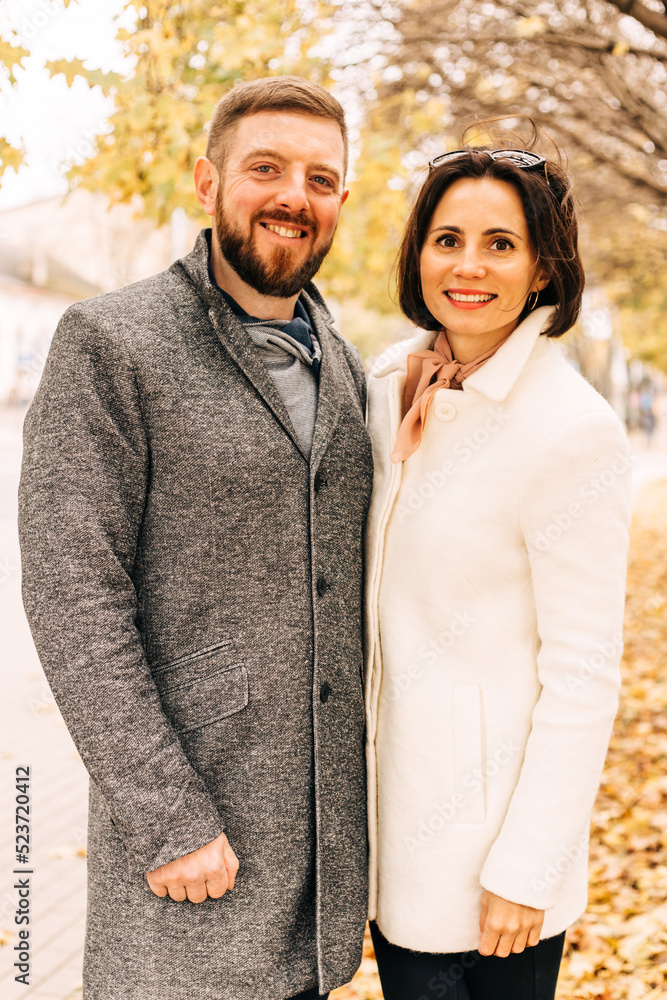 Close up portrait of joyful couple hugging with forest autumn nature in background. Bearded man and woman smiling and having fun together in outdoor leisure activity. Close up portrait of joyful couple hugging with forest autumn nature in background. Bearded man and woman smiling and having fun together in outdoor leisure activity.