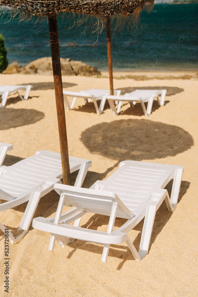 Detail of the deck chairs on a beach with parasols