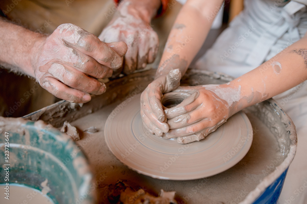 Hands of the master potter and vase of clay on the potter