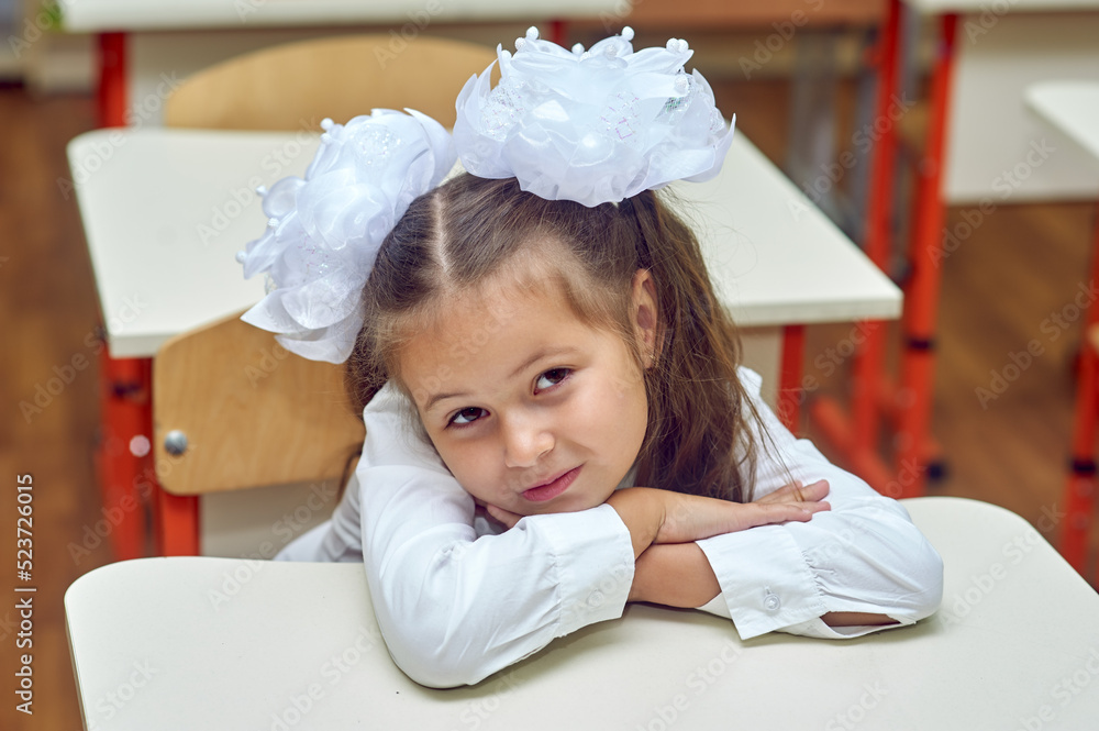 Portrait of a tired elementary school student at her desk