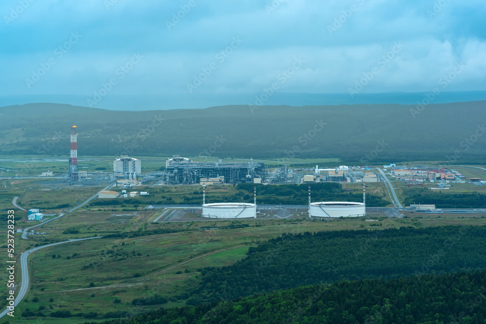 Obraz premium aerial view of plant for the production of liquefied natural gas in a natural area against the backdrop of mountains