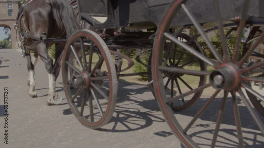 Wheels of Victorian age horse and carriage driving over brick road in castle garden Wheels of Victorian age horse and carriage driving over brick road in castle garden